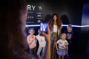 person taking photo of children with wax figure